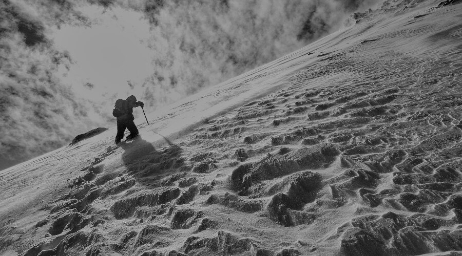Ein Mann in den Bergen im tiefen Schnee
