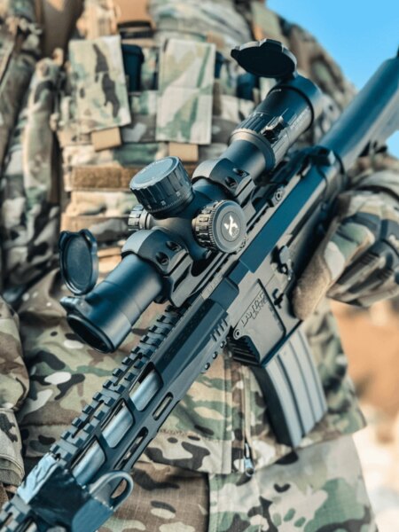 Zielfernrohr Vortex Optics detailliert auf einem modernen Sturmgewehr mit Montage auf Picatinny-Schiene, Schütze in Tarnkleidung. Foto: Rigad