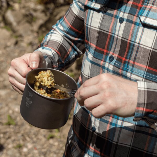 Titanbecher von Keith mit Essen in der Hand bei Outdoor-Aktivitäten. Foto: Rigad