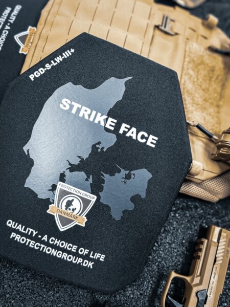 Hartballistische Platte mit der Seite STRIKE FACE (PGD); im Hintergrund Plattenträger und Dienstpistole, Detail vor dem Einsetzen in den Träger.