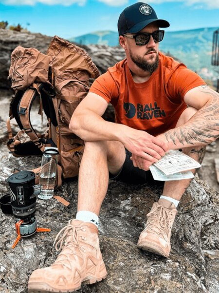 Outdoor-Tourist mit Rucksack, Baseballmütze und Wasser als Schutz vor Hitzschlag. Foto: Rigad