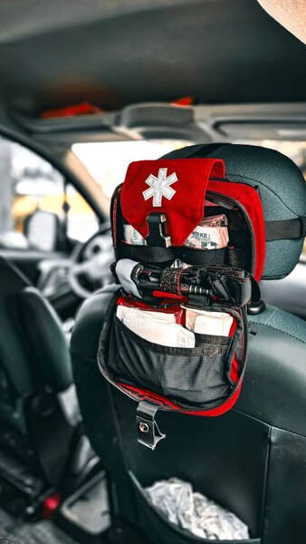 Ein aufgeklappter Erste-Hilfe-Kasten von Helikon-Tex, befestigt an der Rückseite des Autositzes – übersichtliche und schnell zugängliche Ausrüstung für Notfälle im Winter. Foto: Rigad