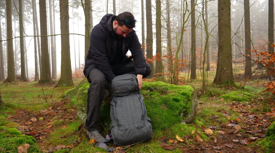 Der Mann packt seinen Rucksack für die Wanderung.
