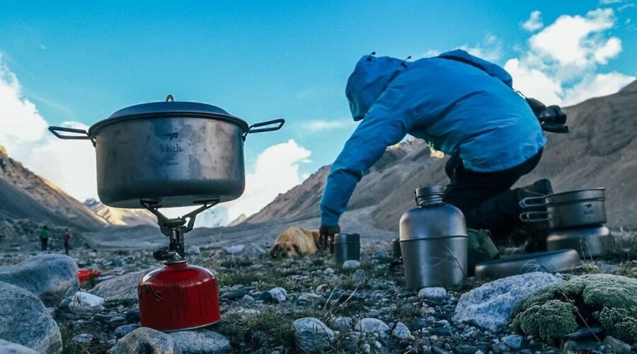 Der Mann kocht in Outdoor-Geschirr