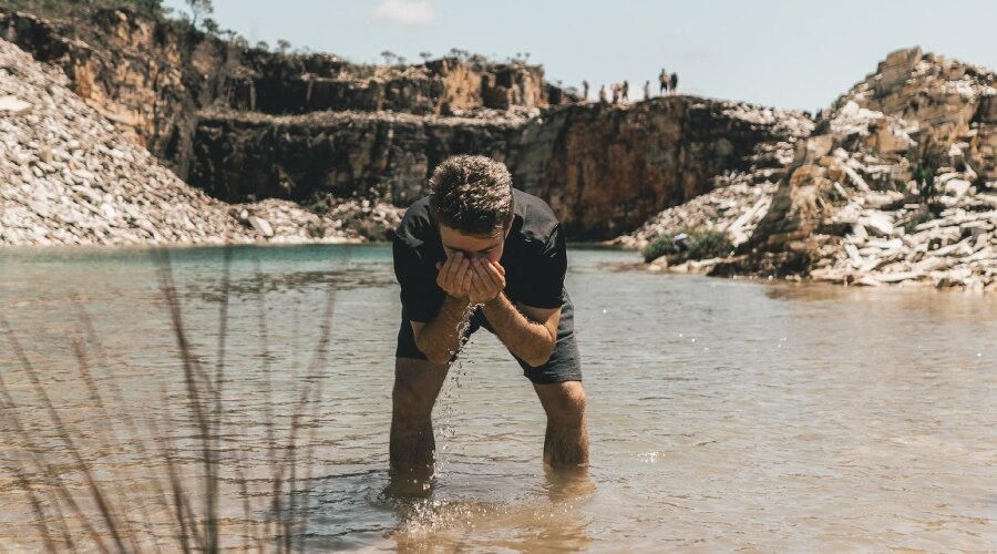 Der Mann wäscht sich das Gesicht im Fluss