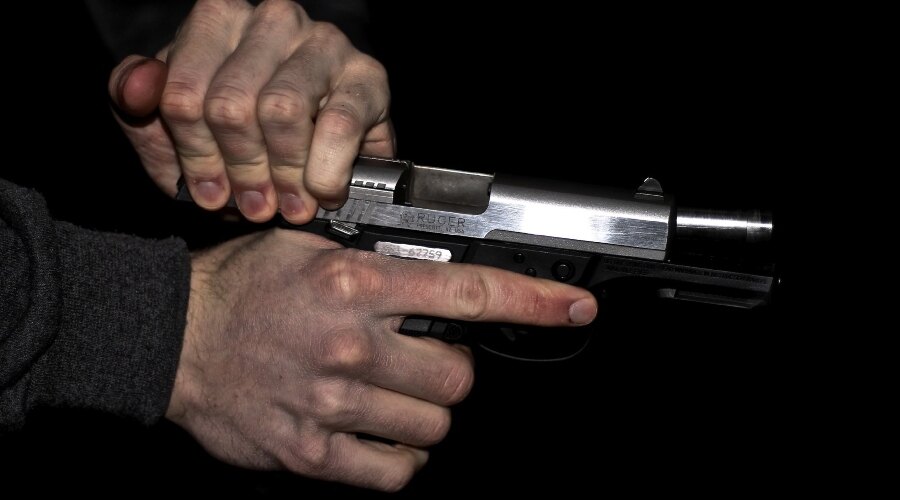 Männerhände halten eine Waffe