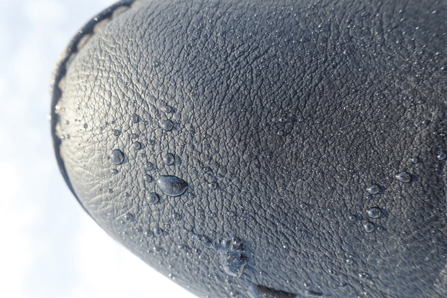 Detail von Wassertropfen auf der Spitze eines Lederschuhs. Quelle: pexels