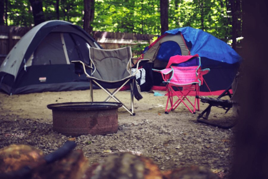 Campingstühle vor dem Zelt im Campingplatz. Quelle: https://www.pexels.com/cs-cz/foto/drevo-krajina-dovolena-leto-2662816/