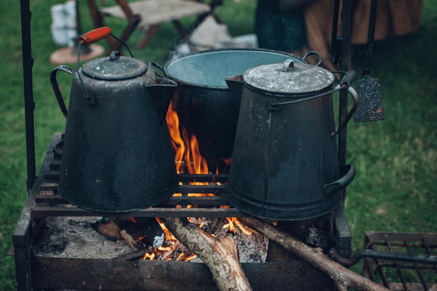 Kessel und Topf auf dem Grillrost beim Camping. Quelle: https://www.pexels.com/cs-cz/foto/221436/