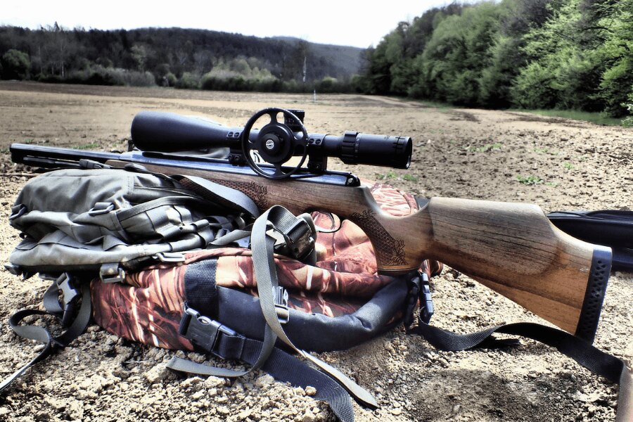 Luftgewehr mit Optik auf einem Rucksack abgestützt.