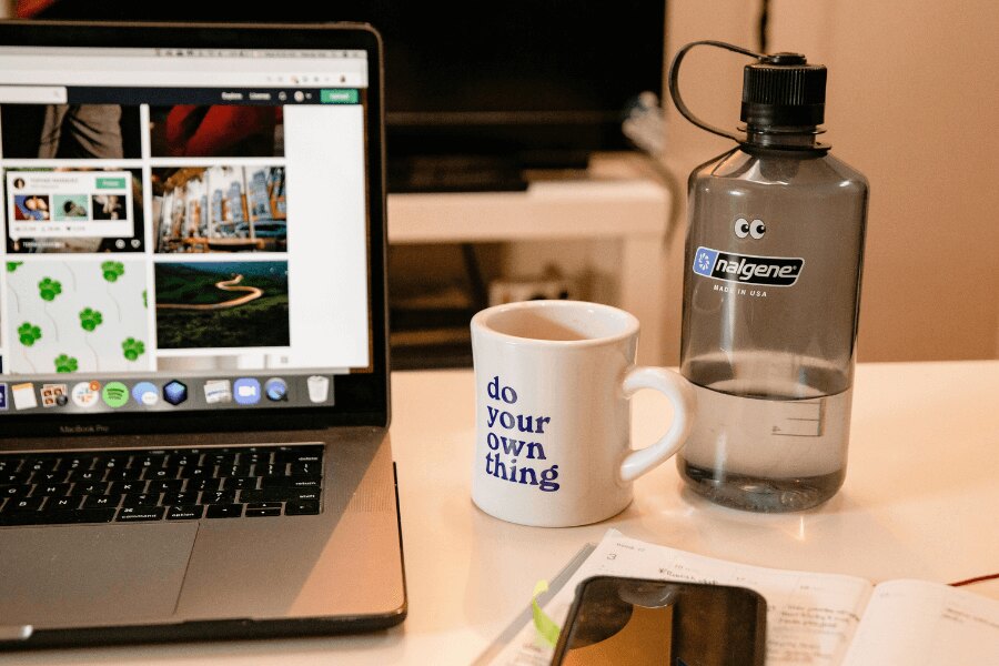 Nalgene-Flasche auf dem Schreibtisch neben dem MacBook. Quelle: https://www.pexels.com/cs-cz/foto/kava-salek-notebook-internet-3959986/