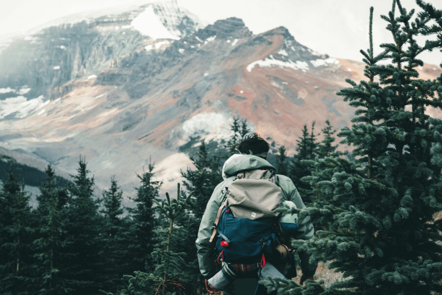 Mann in den Bergen in einer Funktionsjacke. Quelle: https://www.pexels.com/cs-cz/foto/snih-osoba-hora-tramp-10772381/