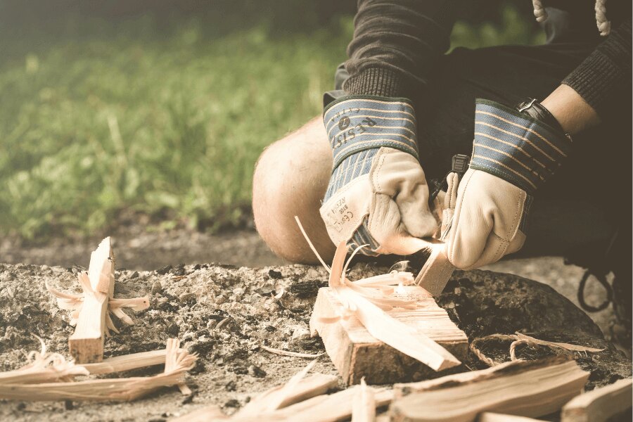 Entzünden eines Feuers mit Handschuhen und einem Feuerstahl. Quelle: https://www.pexels.com/cs-cz/foto/167708/