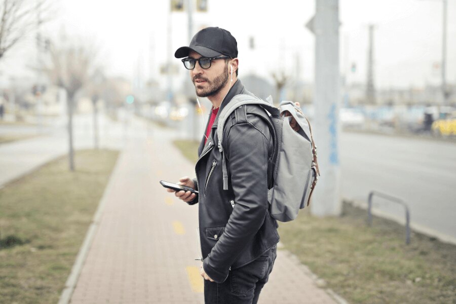 Ein Mann auf der Straße mit einem Rucksack und einem Handy. Quelle: https://www.pexels.com/cs-cz/foto/845457/