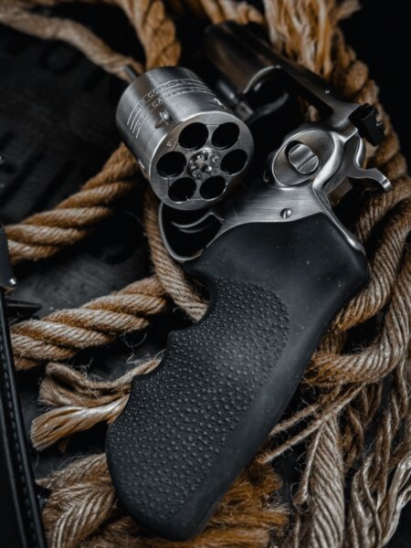 Detail einer modernen Revolver mit ausgedrehtem leerem Zylinder und schwarzem Gummigriff.