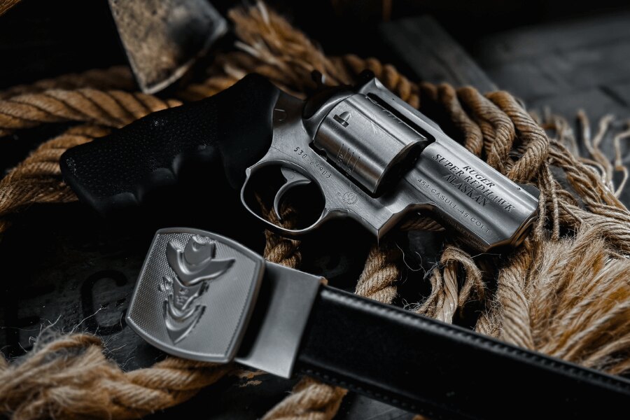 Ruger Super Redhawk Alaskan Revolver im Kaliber .454 Casull auf ein Seil neben einem Ledergürtel gelegt.