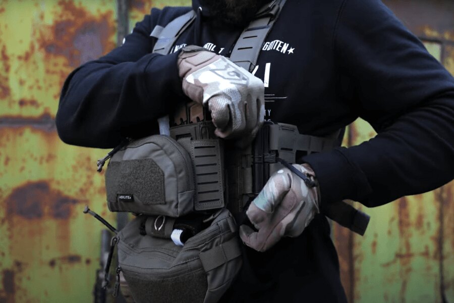 Der Mann mit Chest Rig Reaper™ Agilite Gear<sup>&reg;</sup> mit Magazintaschen passt die Einstellungen an. Quelle: Rigad - video