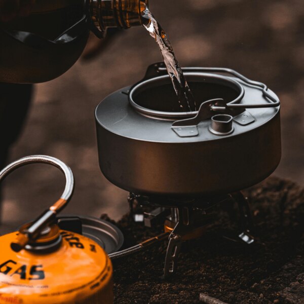 Outdoor-Kochen in der Natur. Quelle: https://www.pexels.com/cs-cz/foto/voda-misa-kempovani-lahev-20397578/
