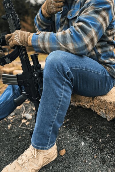 Ein Mann in Treadstone Jeans<sup>&reg;</sup> Helikon-Tex<sup>&reg;</sup> Hosen, einem karierten Hemd und einem Gewehr. Foto: Rigad