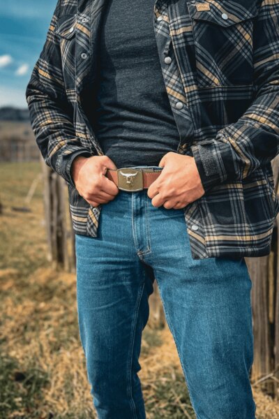 Ein Mann in Treadstone Jeans<sup>&reg;</sup> Helikon-Tex<sup>&reg;</sup> Hose im karierten Hemd hält seinen Gürtel. Foto: Rigad