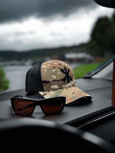 Multicam Trucker-Cap mit dem Logo von Unity Tactical und Schießschutzbrille auf dem Armaturenbrett. Foto: Rigad