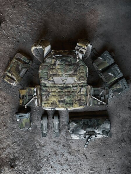 Plattenträger K-ZERO™ SF Agilite<sup>®</sup> umgeben von Zubehör, einschließlich Pincer Placard™ Taschen, BattleShell Hülle und Rückentasche Rear Hanger. Foto: Rigad