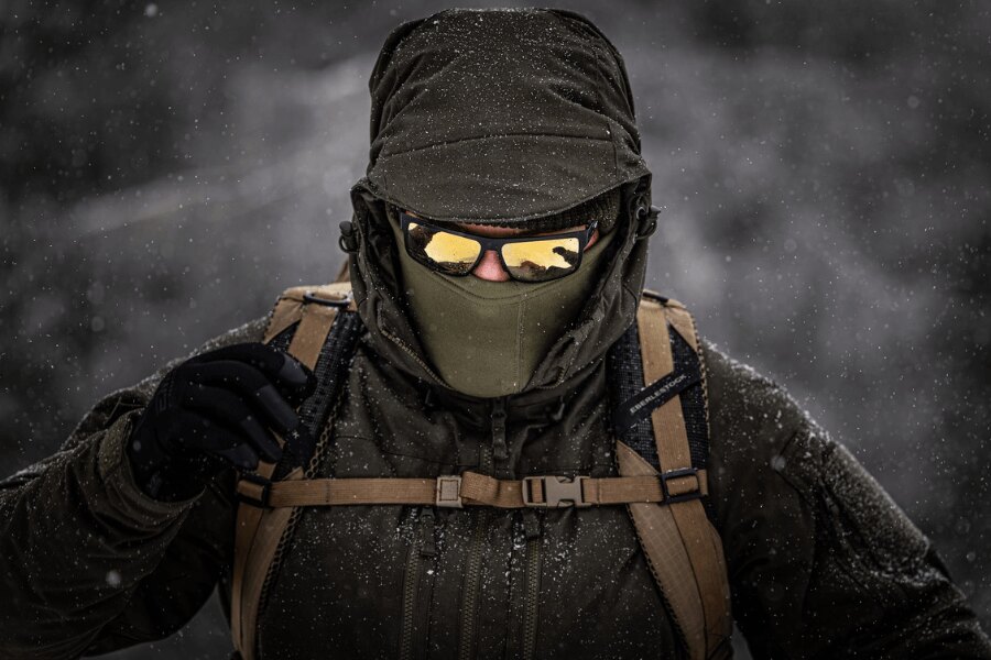 Ein Tourist im Wintersturm in einer robusten isolierten Helikon-Tex Yukon Jacke mit Balaklava und Schutzbrille beim anspruchsvollen Winteraufstieg. Foto: Rigad