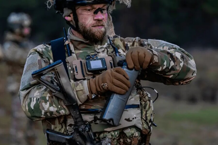 Ein Operator in taktischer Ausrüstung öffnet das Qore Performance ICEPLATE<sup>®</sup>-Hydratationssystem während des Feldtrainings.