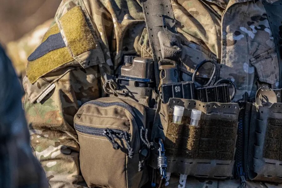 Detail der taktischen Ausrüstung mit Qore Performance ICEFLASK<sup>®</sup>-Trinkflasche in der Plattenträger montiert.