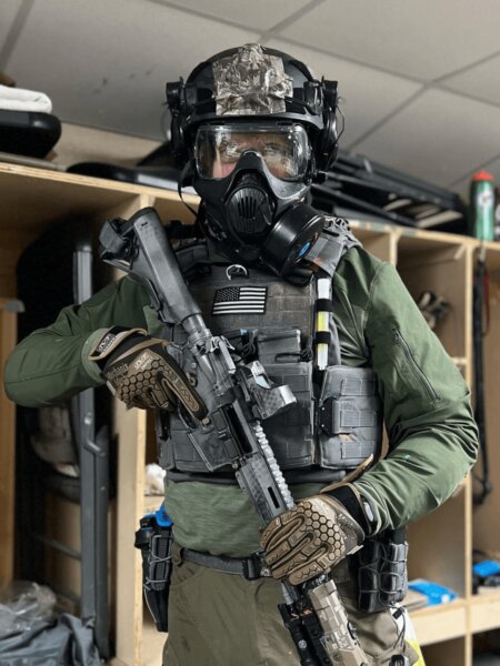 Angehöriger einer Spezialeinheit mit Busch PROtective Helm, Schutzmaske und taktischer Ausrüstung ausgestattet.