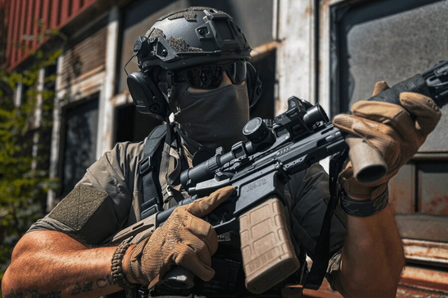 Ein Schütze in taktischer Ausrüstung hält ein modernes PCC-Gewehr mit Optik während einer Schießübung.