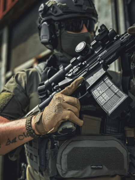 Detail eines Schützen in taktischer Ausrüstung mit einer PCC-Karabiner mit Optik und Magazin.