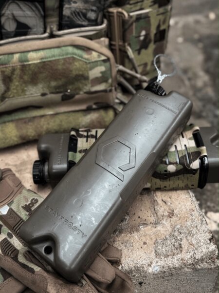 ICEFLASK<sup>®</sup> Qore Performance neben einem Plattenträger und weiterer taktischer Ausrüstung.