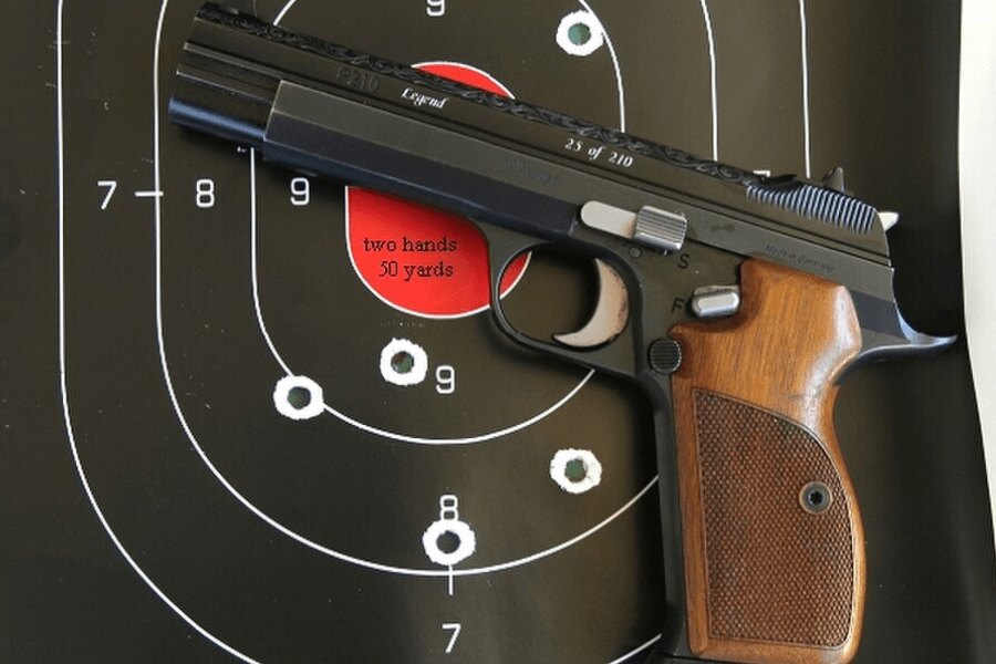 Eine SIG P210-Pistole vor der Schießscheibe platziert.