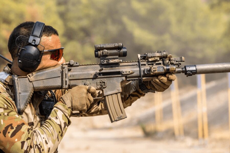 Schütze mit einem FN SCAR-Gewehr, ausgestattet mit Kollimator, Taschenlampe und Schalldämpfer.