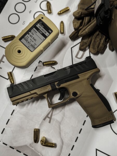 Die Walther PDP Full Size Pistole mit Schießtimer, Munition und Handschuhen auf einer Zielscheibe platziert.