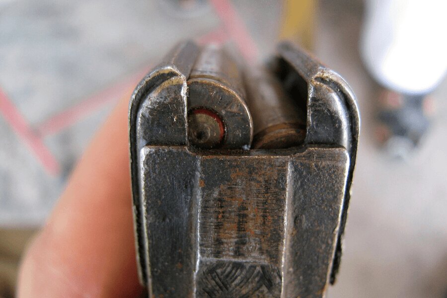Detail des oberen Teils eines abgenutzten Stahlmagazins einer AK-47 mit 7,62 × 39 mm Patronen.