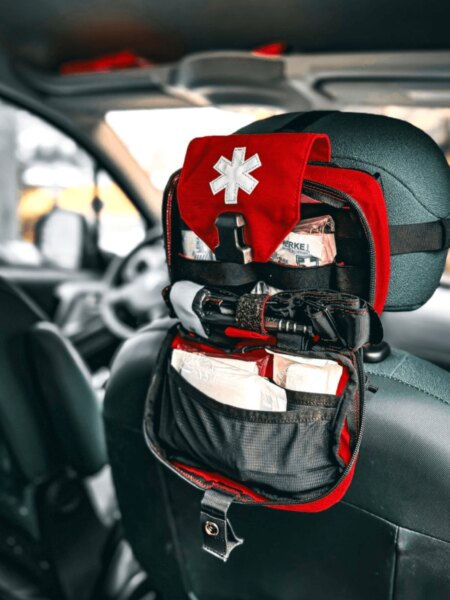 Ein offener Erste-Hilfe-Kasten, der an der Rückenlehne des Vordersitzes des Autos befestigt ist.
