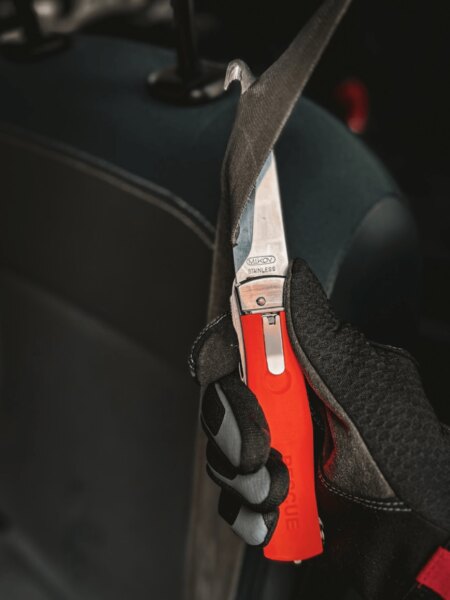 Rettungsmesser Mikov schneidet den Sicherheitsgurt im Auto.
