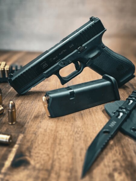 Glock 17 Gen5 mit mechanischen Visierungen auf dem Tisch mit Magazin, Munition und Messer.