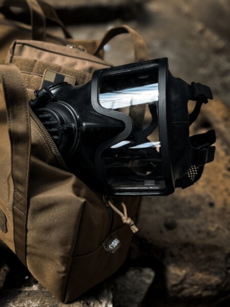 Detail der Vollgesichtsschutzmaske AVEC mit Panoramasichtfeld, auf dem Rucksack platziert.