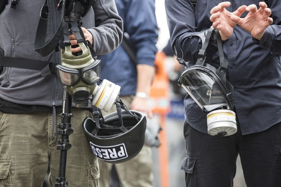 Zwei Männer, die Gasmasken halten