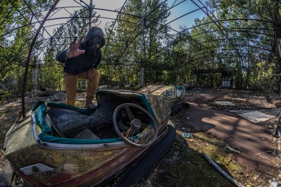 Ein Mann mit einer Gasmaske bei verlassenen Attraktionen