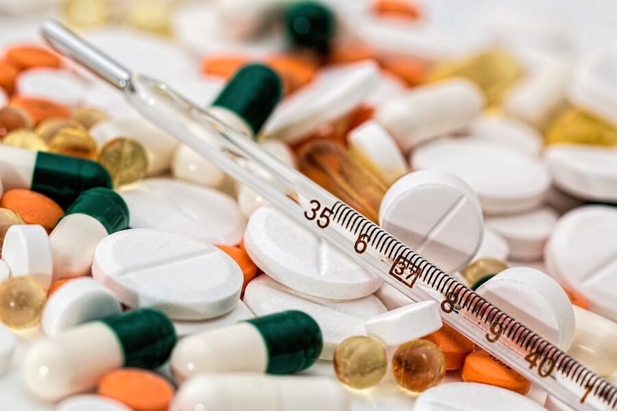 Ein Haufen Tabletten mit einem Thermometer