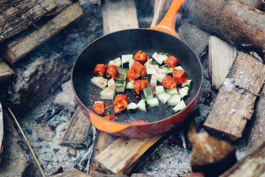 Kochen auf einer Pfanne im Lagerfeuer